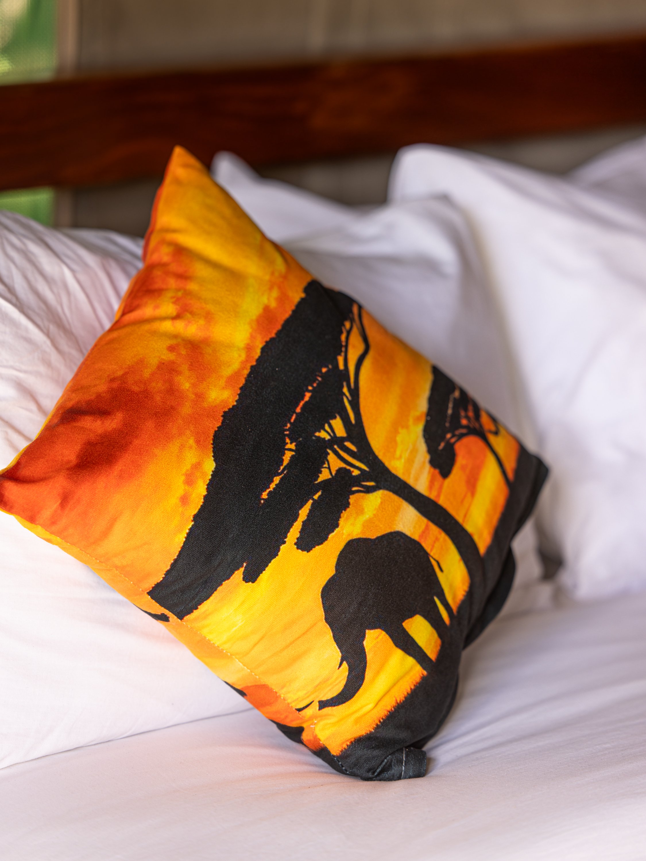 Safari-themed cushion detail on the bed at Enkoropil